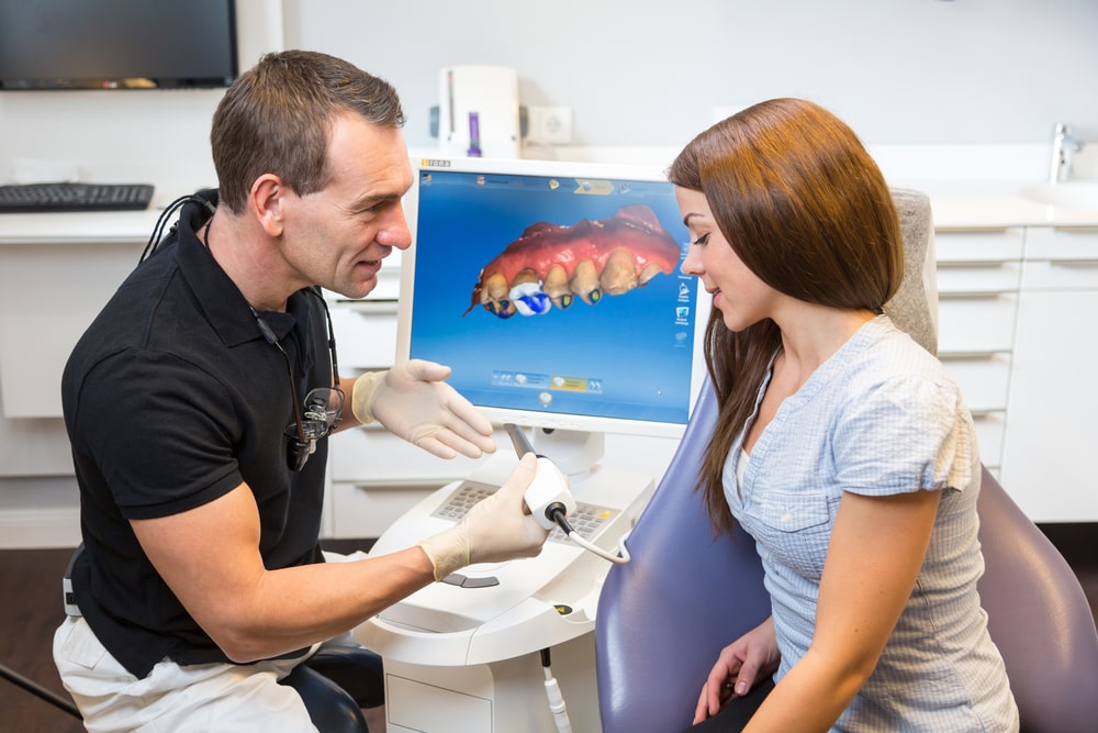 Un dentiste explique le processus CEREC à sa patiente