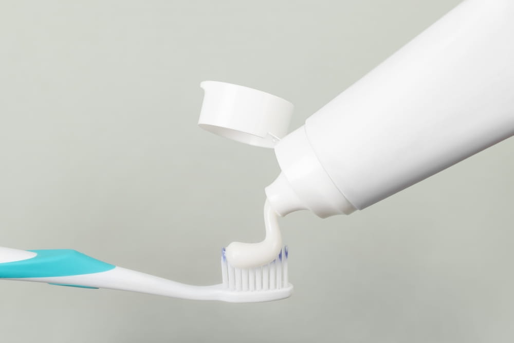 Une grosse quantité de dentifrice au fluor est appliqué sur une brosse à dents