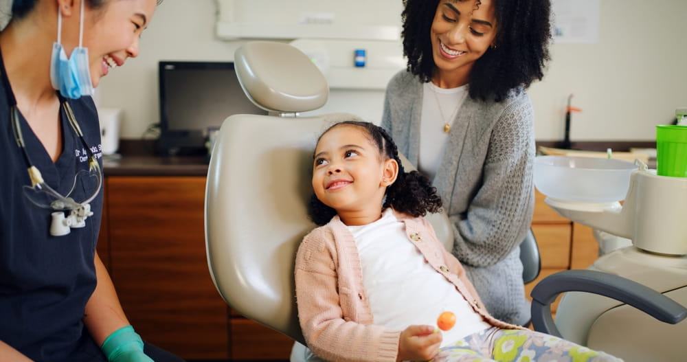 Une petite fille pendant sa visite dentaire qui se déroule sans peur du dentiste